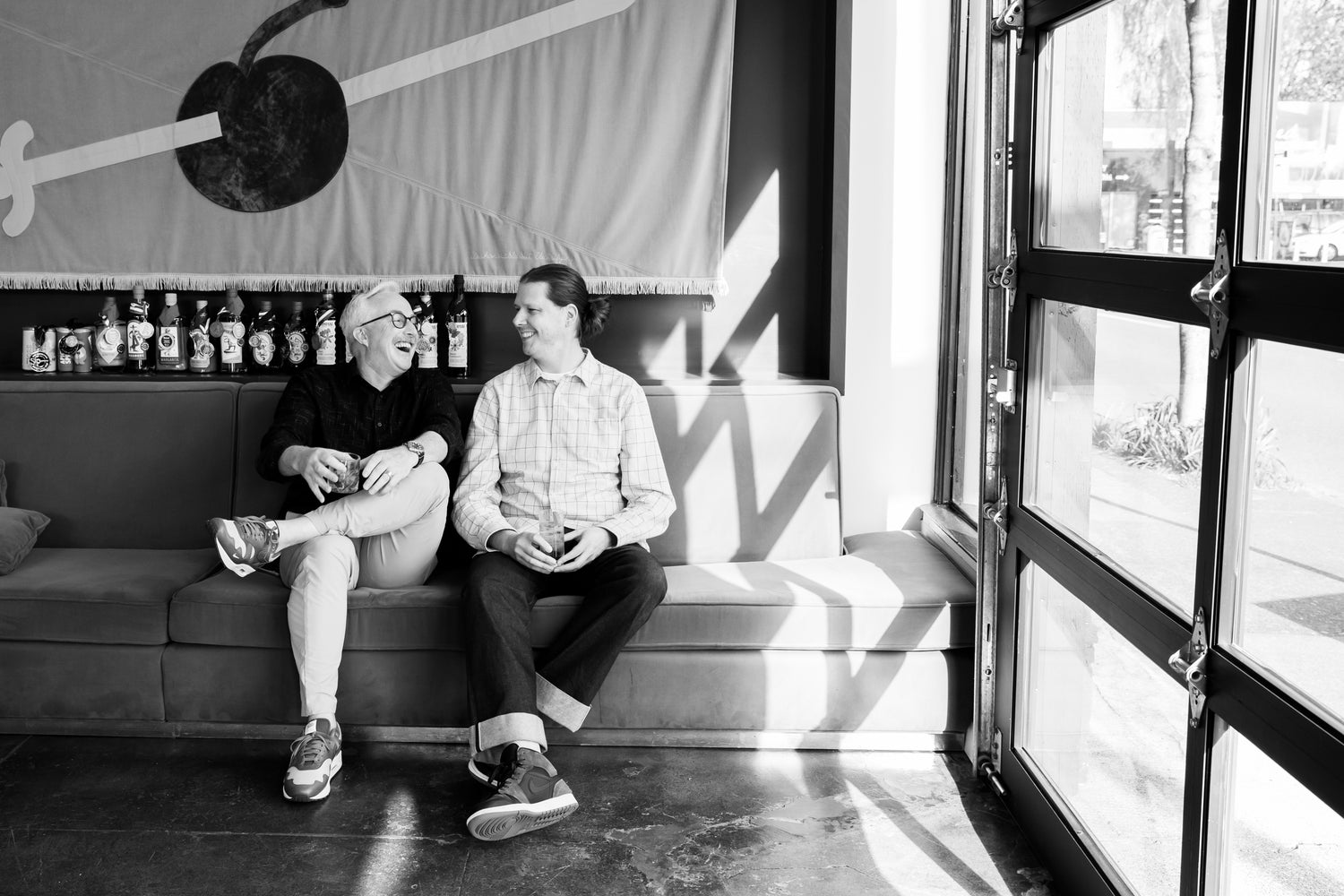 Photo of Founders Cy Cain and Casey Richwine enjoy a cocktail together in the tasting room. 